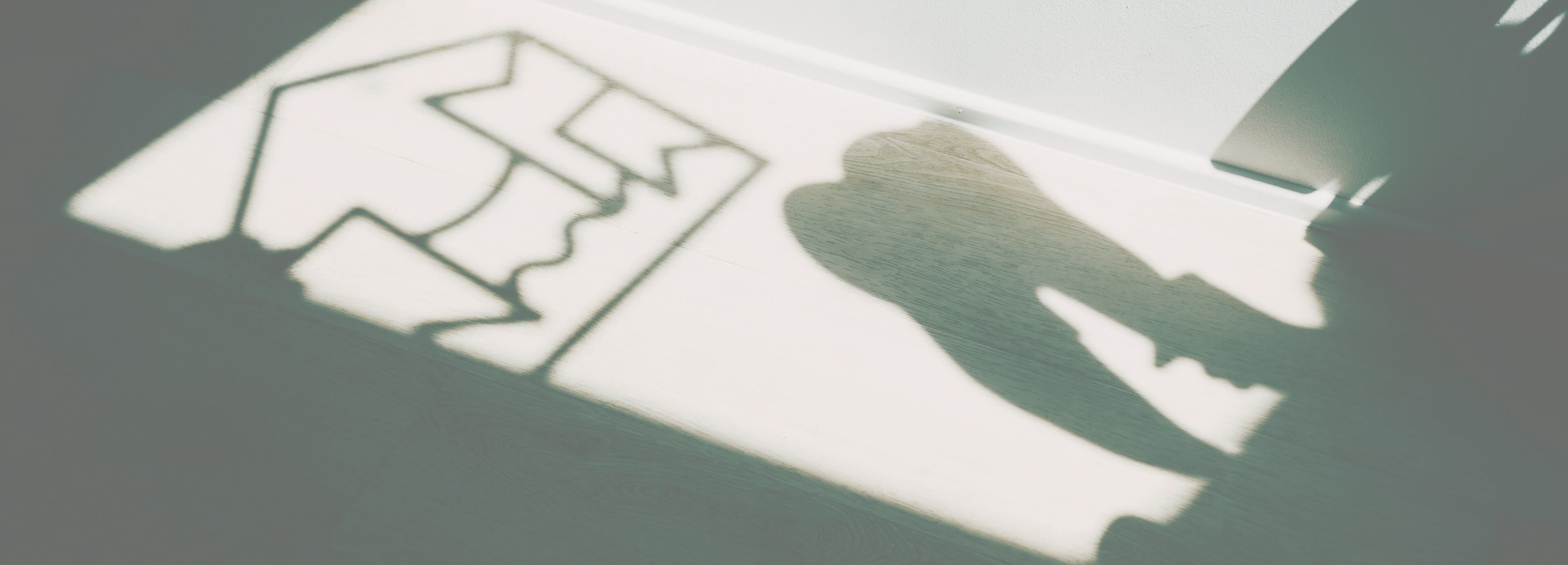 Die Sonne zeigt das Logo der Zahnarztpraxis Villa Mundgesund an der Wand